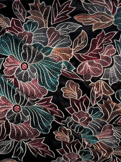 The jewel-toned floral embroidery on this black satin fabric creates a look of pure opulence. It's the perfect choice for a dramatic evening gown or a statement jacket.