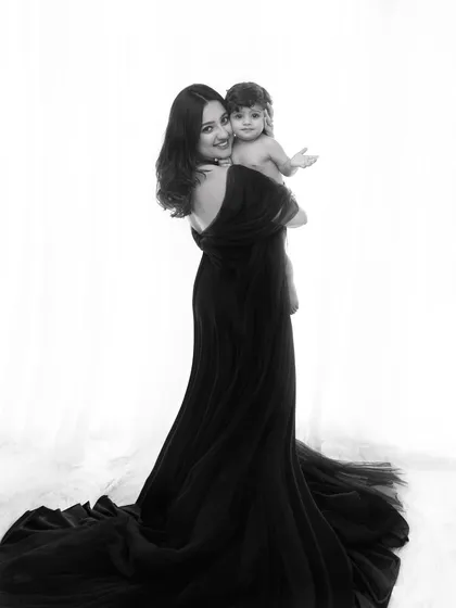 The elegance of motherhood captured in a classic black and white fine art portrait. The flowing black gown, part of my client wardrobe, adds a touch of drama and timelessness to this intimate mother and child moment.