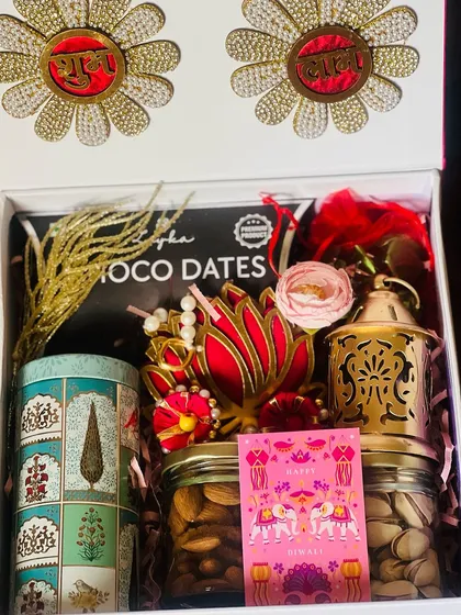I also handle corporate and bulk orders for festivals like Diwali. This hamper features traditional elements like a brass lantern and dry fruits, presented in a premium box with auspicious "Shubh Labh" motifs.