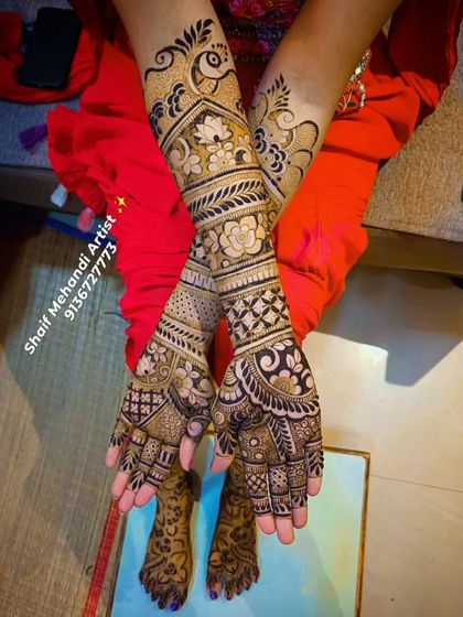 A full-arm bridal design featuring a mix of peacocks, lotuses, and floral bands. The patterns are crossed over each other for a unique photo opportunity.