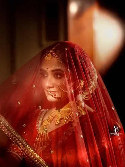 A bride captured in a moment of quiet reflection, her face partially veiled. This moody, intimate style of wedding photography focuses on the internal emotions of the day, not just the external celebration.