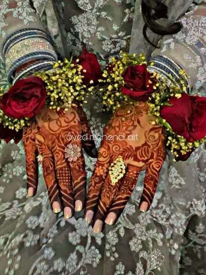 The final stained look of an engagement henna, complete with floral bracelets.