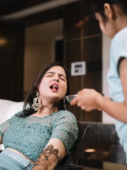 When you're the bride at the mehendi, you get taken care of. Here, Disha is being fed by her cousin, a funny and real moment that happens when your hands are covered in henna.