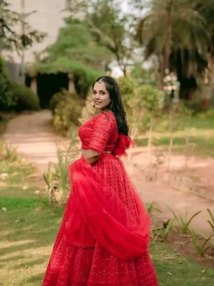 A happy client in a classic red lehenga, perfect for any wedding celebration. The simple elegance of this piece makes it a versatile rental option.