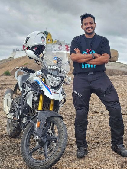 A rider stands proudly next to his BMW GS 310. Our training gives you the confidence to take your bike to incredible places you might not have attempted before.