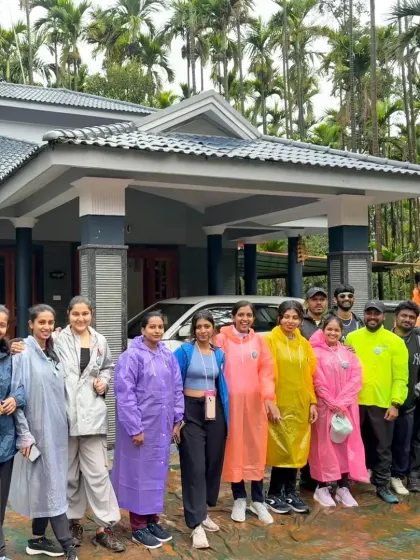 Our trekkers in colorful raincoats outside their modern homestay, surrounded by lush areca nut plantations.