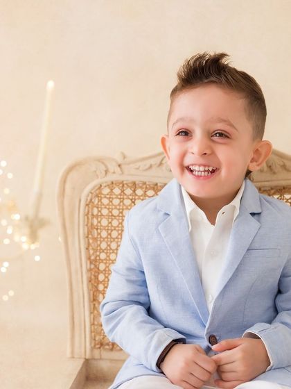 A joyful solo portrait of a little boy. His huge, happy smile is infectious in this beautifully lit, classic child portrait.