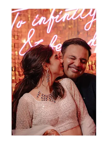 A sweet kiss on the cheek against a glittering backdrop. The perfect end to a beautiful sangeet performance.