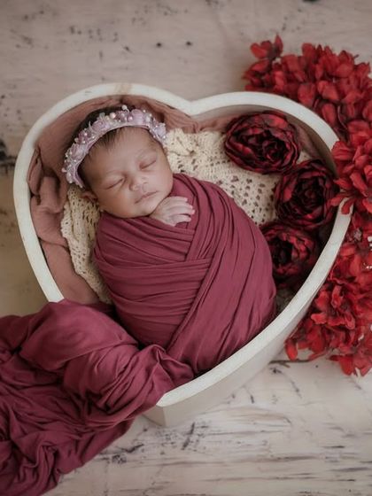 Love's purest form. This photo shows how a simple swaddle and a heart-shaped prop can create a powerful and emotional image.