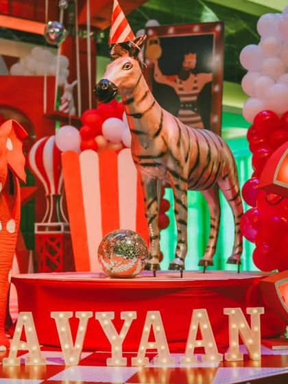 A close-up of the main stage decor for Avyaan's 3rd birthday. The light-up number, custom animal props, and balloon arrangements come together to create a vibrant and celebratory focal point.