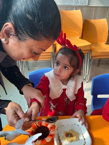 A sweet moment of interaction between a teacher and a student during the cookie decorating activity.