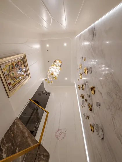 A worm's-eye view of the staircase, capturing the chandelier, the feature wall, and the art piece on the upper level. This shows our attention to detail at every level of the design.