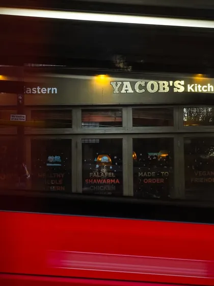 A shot of Yacob's Kitchen in London, captured with a red double-decker bus blurring past. This single image perfectly places the restaurant in its iconic location.