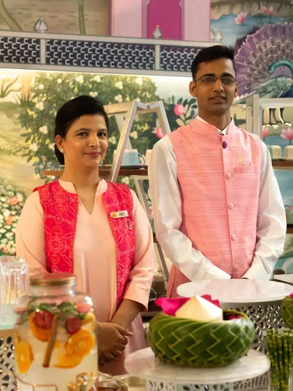 Our staff at a beautifully arranged beverage station, ready to serve guests with a smile. The station features infused water and elegantly presented drinks.