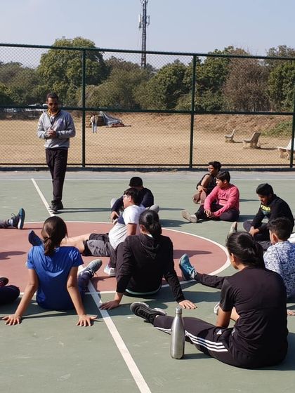 Coaching goes beyond physical drills. In this photo, I am talking with our players during a break, discussing strategy and the mental aspects of the game to build their basketball IQ.