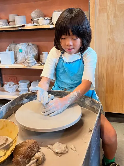 This young potter is completely absorbed in her work at the wheel. Our summer camps provide a supportive environment for kids to explore their creativity.