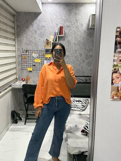 A recent mirror selfie from my album. Just a casual, everyday look with a bright orange shirt and comfortable jeans.