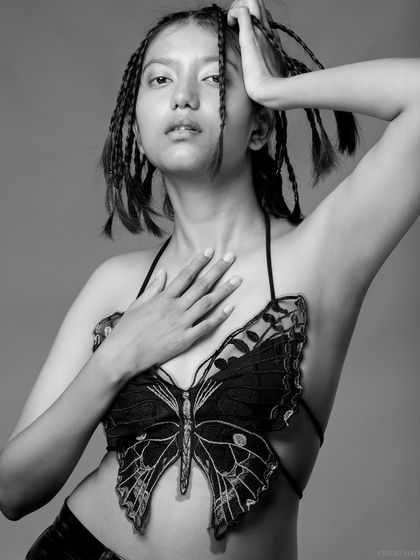 A black and white portrait with the butterfly top, with a dynamic and artistic pose.