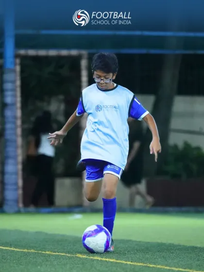 Mastering ball control is the first step to becoming a great player. This young footballer is captured practicing his dribbling, a foundational skill we emphasize in our grassroots football coaching program.