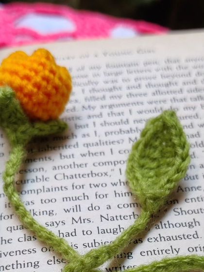 A yellow tulip bookmark inside a book.