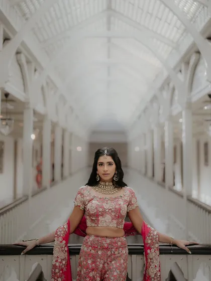 A stylish portrait of Nandini and Sahil at the Taj Mahal Palace, Mumbai. The grand, symmetrical hallway provides a stunning architectural backdrop for this elegant and poised couple shot.
