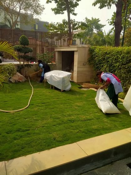 Our maintenance crew at work, clearing leaves and debris to keep a residential lawn tidy. Regular clean-ups are part of our comprehensive garden care packages.