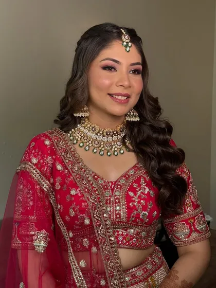 This portrait showcases the beautiful balance of the makeup. The warm red tones on the eyes are complemented by a natural lip color, letting the bride's smile be the focus.