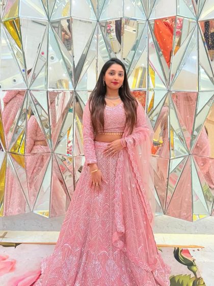 A full look of the light pink sequin lehenga against a modern backdrop. This outfit is a favorite rental for bridesmaids and wedding guests.