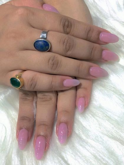 A still photo of the elegant nude pink almond nails.