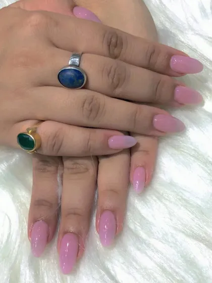 A still photo of the elegant nude pink almond nails.