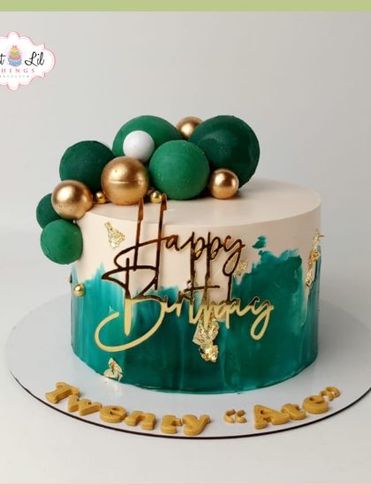 "Twenty Ate" in style! A sophisticated birthday cake with a deep green brushstroke effect, gold leaf, and a cascade of green and gold spheres.