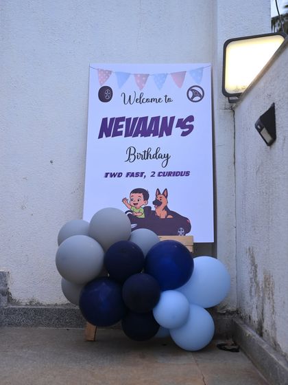 A welcome sign for the "Two Fast, 2 Curious" birthday party, setting a cool tone with its car and dog graphic.