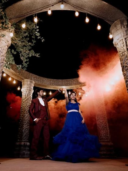 A fun and dynamic shot of a couple dancing. The swirling blue ball gown and the use of colored smoke create a magical and energetic pre-wedding photo.