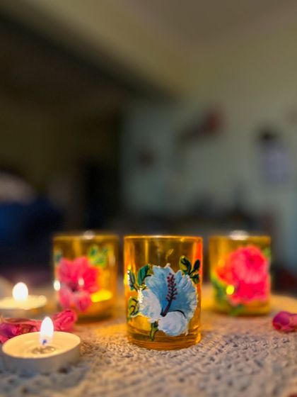 The warm glow of tea lights inside our hibiscus-painted candle holders.