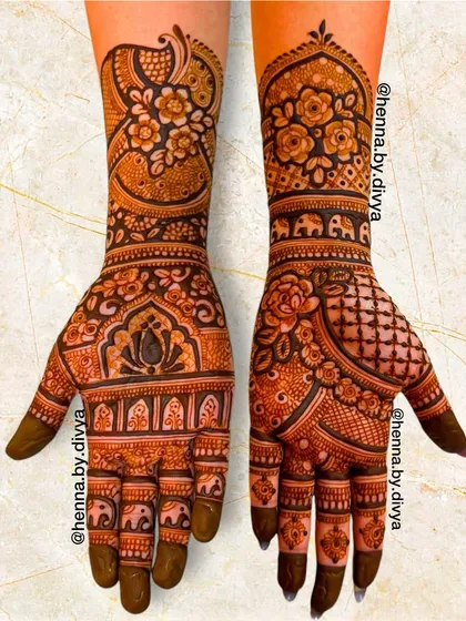 This Indian mehendi design combines floral elements with traditional animals. The arms feature peacocks and elephants, while the palms are filled with a mix of flowers and geometric patterns.