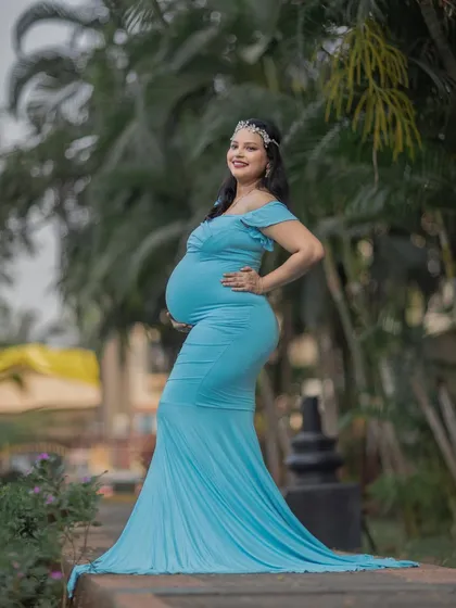 A confident and beautiful solo portrait in a form-fitting sky-blue gown that perfectly shows off the baby bump.