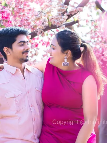 A soft and dreamy portrait with a beautiful flare effect, captured in our pink blossom grove for an artistic pre-wedding photo.