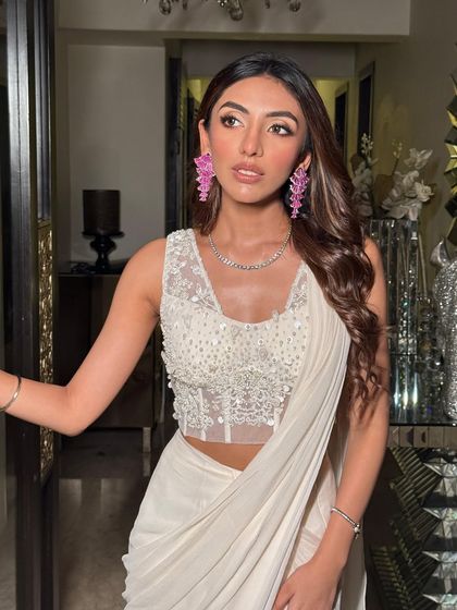 A close-up that captures the beautiful contrast between the neutral outfit and the vibrant pink jewelry.