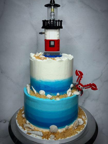 When a bride wants something totally unique, we are all in. This two-tiered beach-themed wedding cake, complete with a real Lego lighthouse and lobster, was so much fun to create for a couple with a great sense of humor.