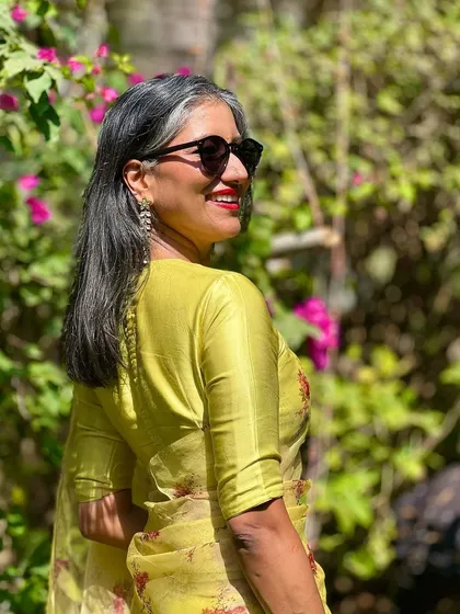 The sunlight brings out the beautiful chartreuse color of this saree. It's a refreshing and stylish choice for any festive occasion.