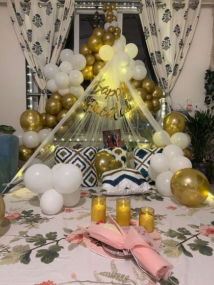 A closer look at the romantic bed canopy setup, showing the details of the fairy lights and the elegant white and gold balloons.