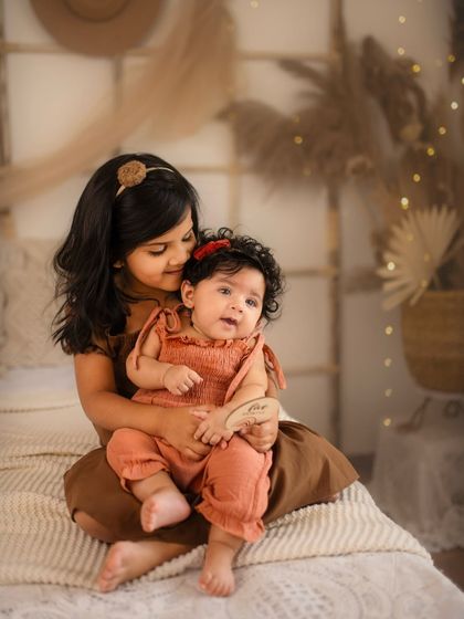 A cozy, rustic-themed milestone session for this sweet baby and her big sister. The warm lighting and earthy tones create a dreamy and intimate feel.