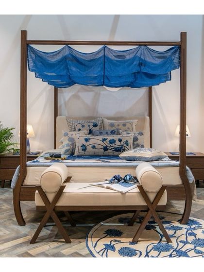 Our bespoke four-poster bed, designed in collaboration with Gaurang Home. The sleek wooden frame, gracefully curved legs, and indigo canopy create a modern yet timeless sanctuary, perfect for today's sophisticated spaces.