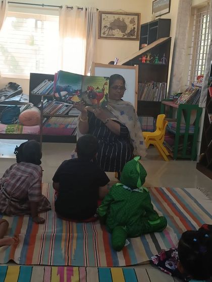 The storyteller shows a picture of a dragon, a classic element of fantasy that always excites the children.