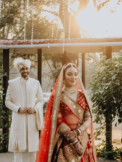 The groom looks on with a smile as his bride walks towards him. A beautiful, candid moment filled with anticipation and love.