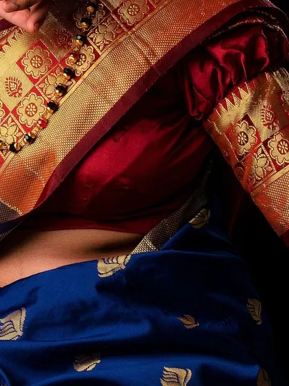 A close-up detail shot focusing on the texture and craftsmanship of the saree and blouse. This type of image is crucial for brands wanting to highlight the quality of their traditional garments, showing the intricate weaving and fabric details.