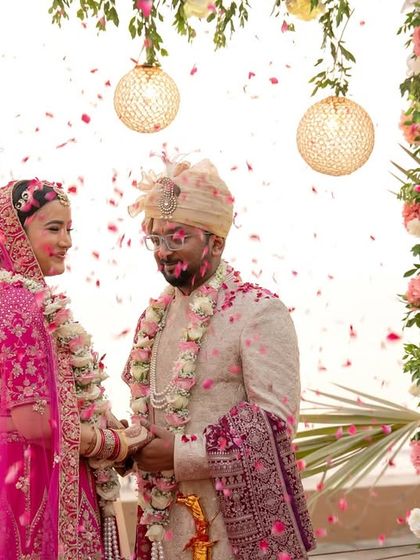 The couple exchanges rings under a beautiful floral mandap by the sea, a perfect destination wedding moment.