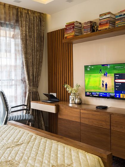 Who needs a stadium when you have this setup? This bedroom combines a comfortable bed with a dedicated media unit and workspace, making it the perfect spot to catch all the cricket action.