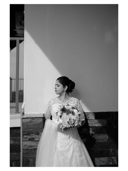 The same artistic portrait in black and white. This version emphasizes the play of light and shadow, giving the image a timeless, classic feel.