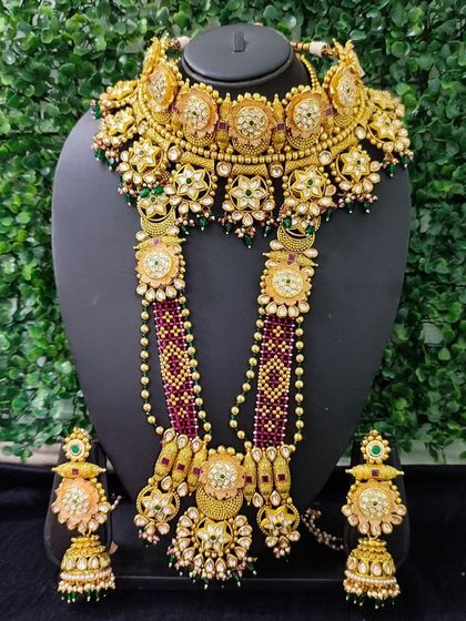 A magnificent bridal set for sale, featuring a choker and a long beaded necklace. The rich colors and intricate kundan work make this a standout piece for any bride.